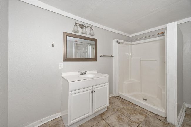 Bathroom with vanity, a shower, and tile patterned flooring | Image 11