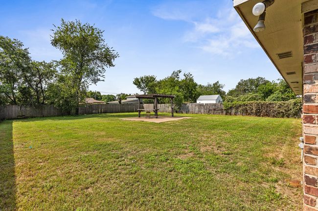 Fenced backyard with a pergola and a patio | Image 9