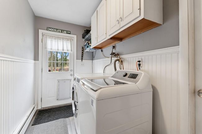 Laundry room with separate washer and dryer, cabinet space, and a wainscoted wall | Image 19