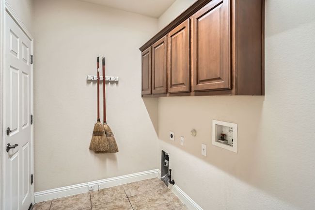 Laundry room featuring baseboards, hookup for a washing machine, hookup for an electric dryer, cabinet space, and hookup for a gas dryer | Image 35