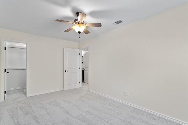 A walk-in closet with built-in shelving ensures ample storage and helps keep your wardrobe organized. | Image 19
