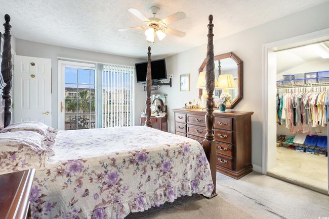 Bedroom featuring light carpet, a spacious closet, a closet, a ceiling fan, and a textured ceiling | Image 23