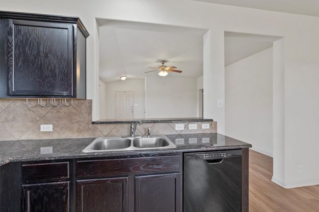 Black appliances complete the space with a modern touch that pairs effortlessly with the dark cabinetry. | Image 8