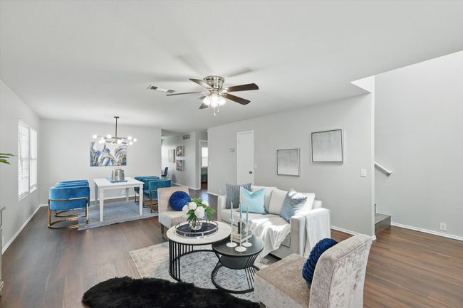 Living room featuring ceiling fan, dark wood-style floors, and a chandelier | Image 8