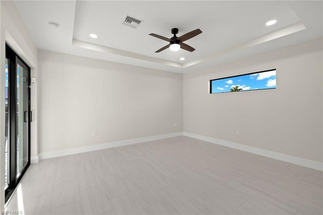 Unfurnished room featuring light tile patterned floors, ceiling fan, and a raised ceiling | Image 21