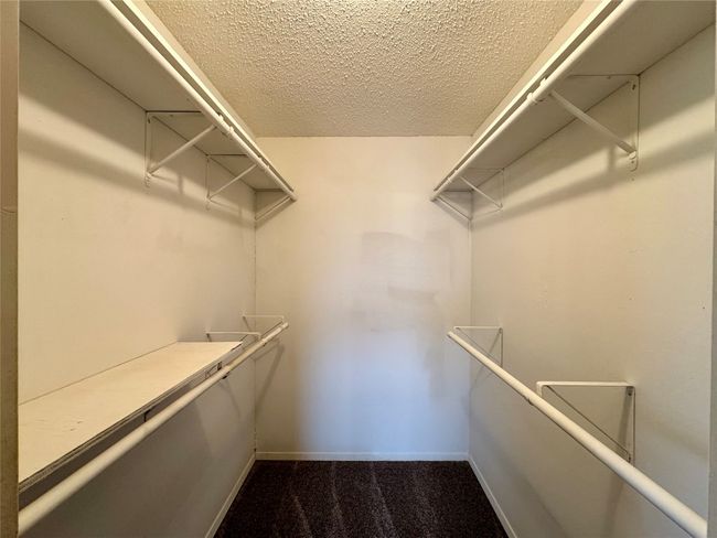Spacious closet with dark colored carpet | Image 23