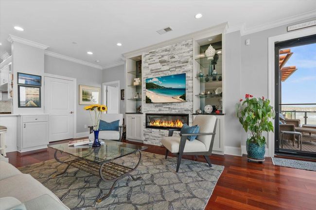 Living room featuring a stone fireplace, ornamental molding, wood finished floors, and recessed lighting | Image 8