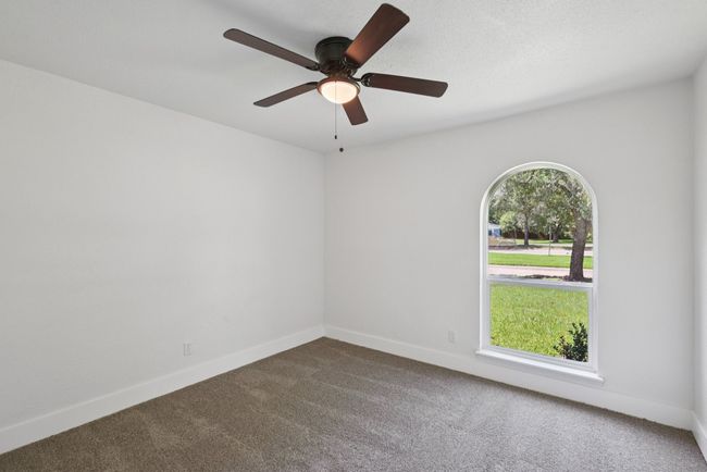 Unfurnished room with dark carpet and a ceiling fan | Image 33