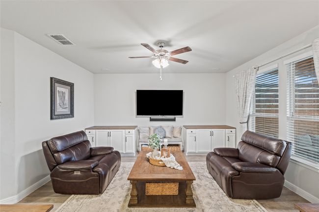 Living area featuring visible vents, baseboards, light wood-style floors, and a healthy amount of sunlight | Image 10