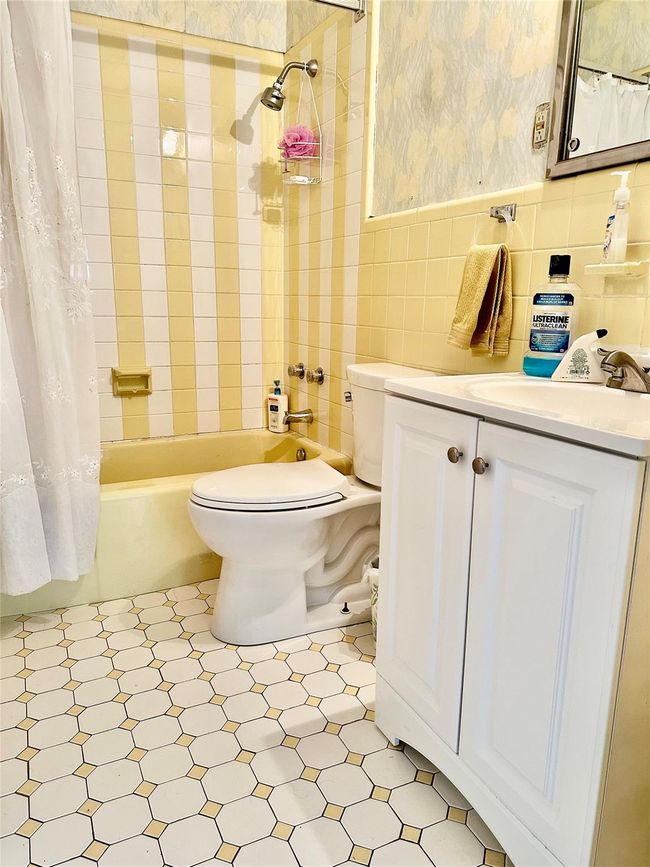 Full bathroom featuring vanity, shower / bathtub combination with curtain, tile walls, and toilet | Image 20