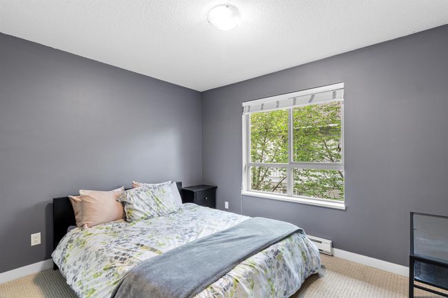 Carpeted bedroom with a baseboard heating unit and baseboards | Image 7