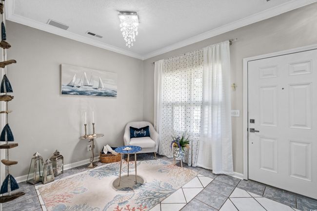 Living area with ornamental molding, baseboards, and light tile patterned flooring | Image 5
