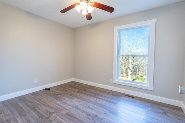 Empty room with ceiling fan, a healthy amount of sunlight, and / wood-style flooring | Image 15