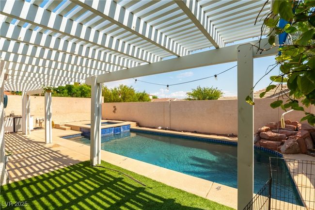 View of pool with a fenced backyard and a pool with connected hot tub | Image 15
