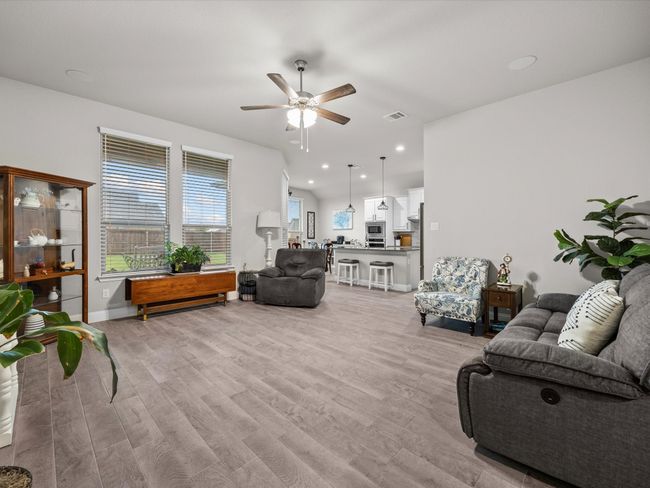 Living area with ceiling fan and light wood-type flooring | Image 14