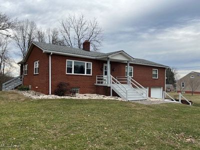 View of front of home with a front lawn and a garage | Image 1