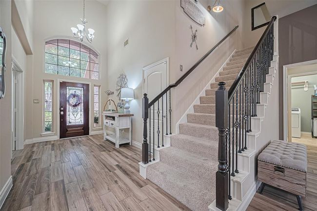 Just beyond the entry, a beautifully crafted staircase with decorative iron balusters makes a stylish statement as it ascends to the upper level. | Image 6