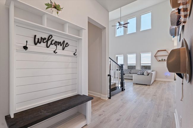 Mudroom with light wood-style floors, baseboards, a towering ceiling, and ceiling fan | Image 5