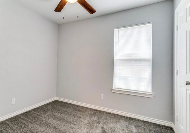 Spare room with a ceiling fan, carpet floors, and baseboards | Image 4