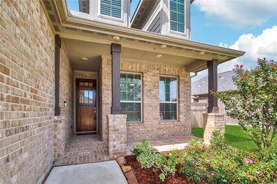 A charming home with a welcoming covered front porch, perfect for relaxing in rocking chairs while enjoying a peaceful morning or afternoon. This all brick home has gutters that outline the 1st story. | Image 3