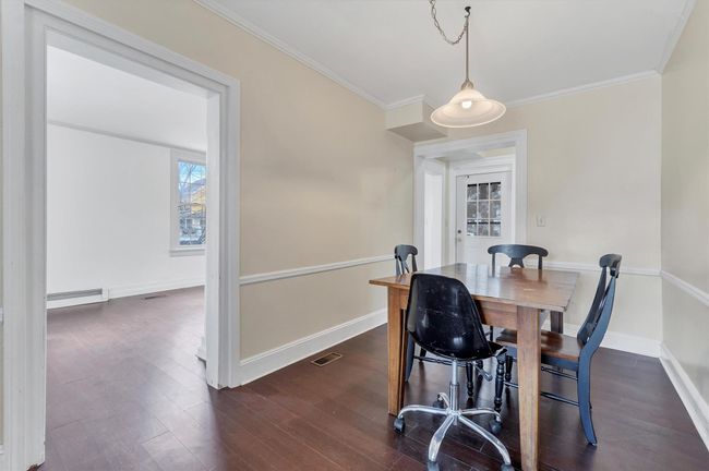 Dining space featuring ornamental molding, dark wood-style flooring, baseboards, and a baseboard heating unit | Image 7