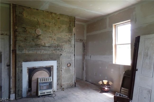 Unfurnished living room with heating unit | Image 9