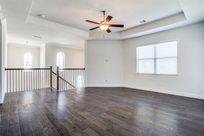Unfurnished room with a tray ceiling, dark wood finished floors, ceiling fan, healthy amount of natural light, and crown molding | Image 14