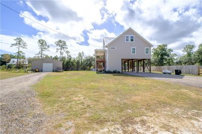 View of front of property with a front lawn, a garage, an outdoor structure, and a carport | Image 2