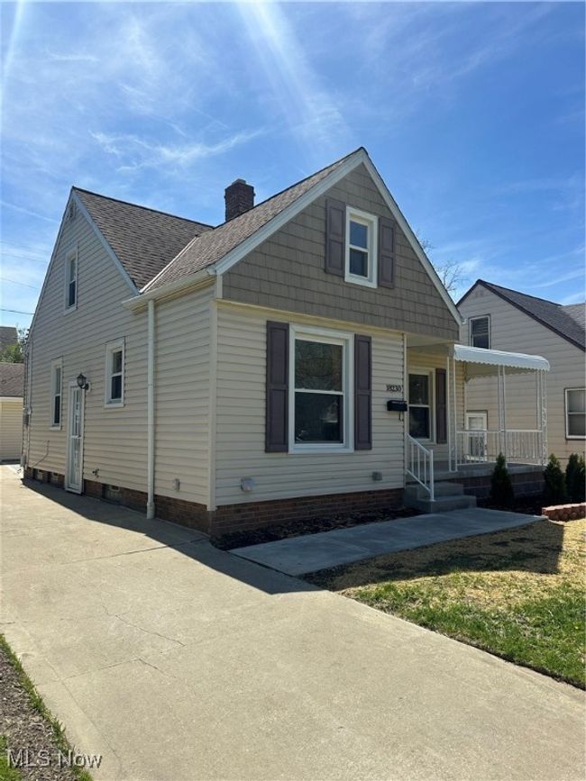 Bungalow featuring a chimney, a porch, and a shingled roof | Image 4