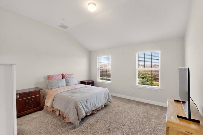Bedroom with lofted ceiling and light colored carpet | Image 16