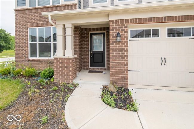entrance to property with brick siding, a garage, and driveway | Image 4