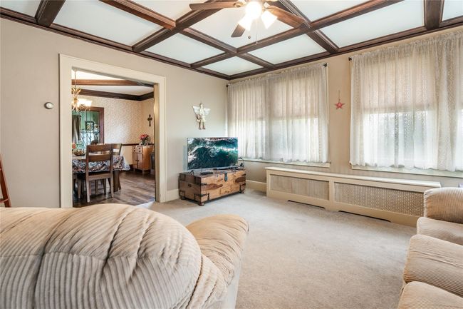 Living area with coffered ceiling, a healthy amount of sunlight, carpet flooring, and ceiling fan with notable chandelier | Image 18