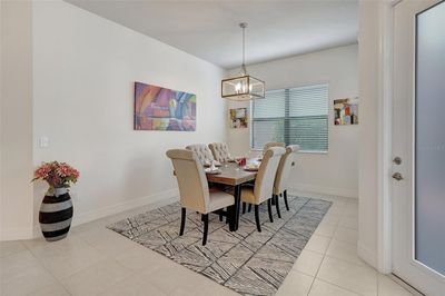 Dining room with ceiling fan and light tile patterned floors | Image 3