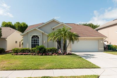 View of front facade with a garage and a front lawn | Image 1