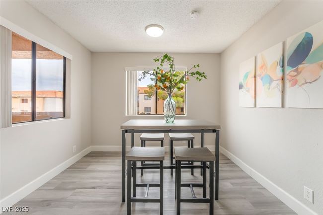 Dining area featuring healthy amount of natural light, a textured ceiling, and light wood-style flooring | Image 7