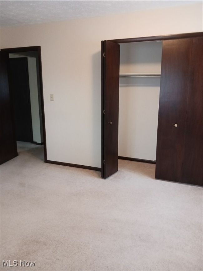 Unfurnished bedroom with light colored carpet and a closet | Image 30