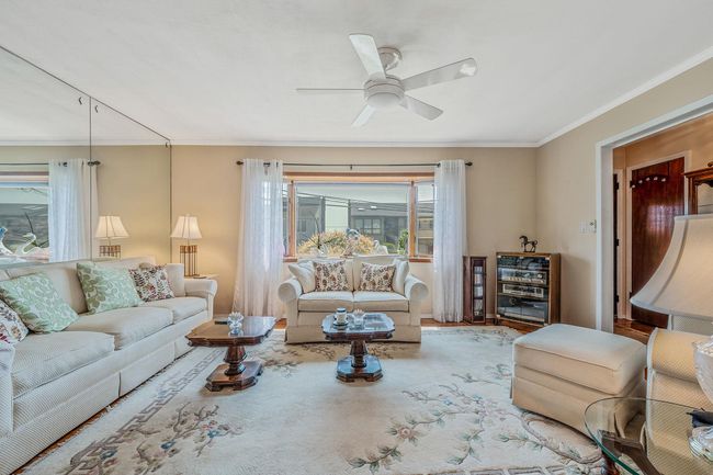 Living area featuring ornamental molding and a ceiling fan | Image 5