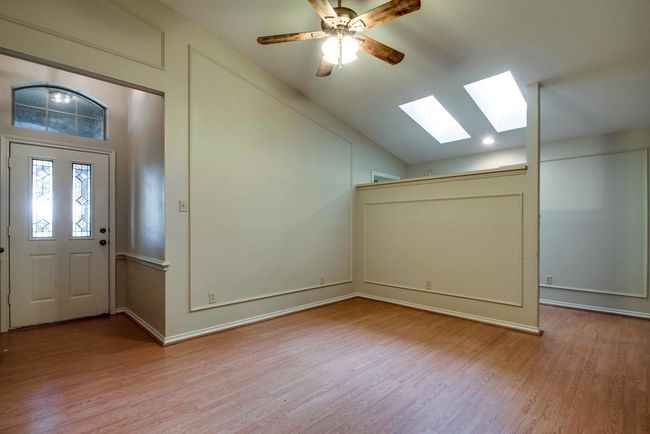 Entryway featuring a skylight, lofted ceiling, light wood-style floors, and a ceiling fan | Image 4