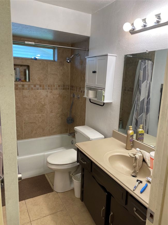 Full bath with vanity, tile patterned flooring, toilet, and shower / bath combo | Image 7