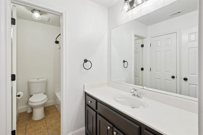 Full bathroom featuring tile patterned flooring, vanity, toilet, and bathing tub / shower combination | Image 33