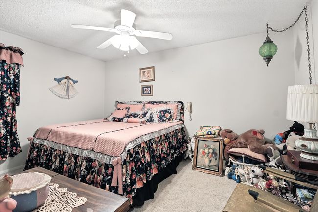 Bedroom with a textured ceiling, carpet floors, and a ceiling fan | Image 31