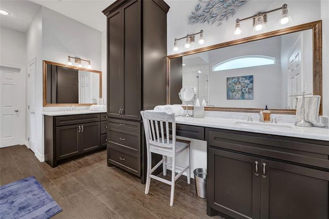 Ensuite primary bath has been remodeled and included double vanities, plentiful handmade wood cabinetry and marble countertops. | Image 20