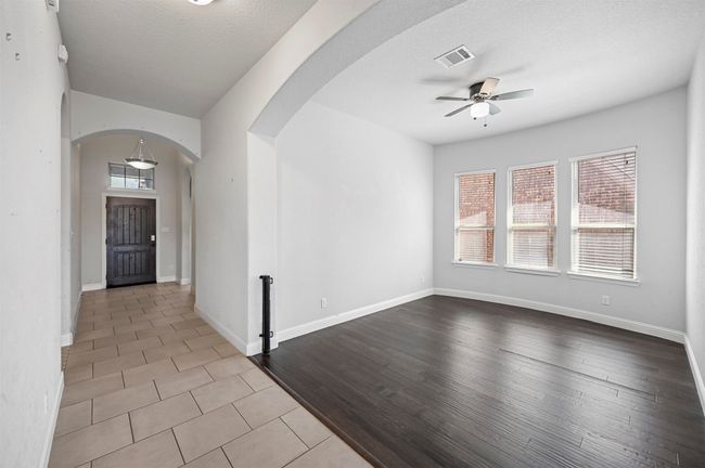 Spare room featuring a ceiling fan, arched walkways, visible vents, and a wealth of natural light | Image 34