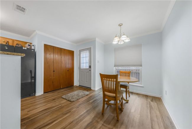 Dining area featuring wood finished floors, a chandelier, and ornamental molding | Image 9