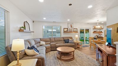 Living room featuring light hardwood / wood-style floors, a textured ceiling, and a chandelier | Image 2