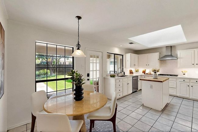 Dining space featuring light tile patterned flooring, plenty of natural light, and a skylight | Image 13