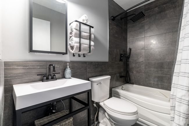 Full bathroom featuring tile walls, toilet, and shower / tub combo | Image 18