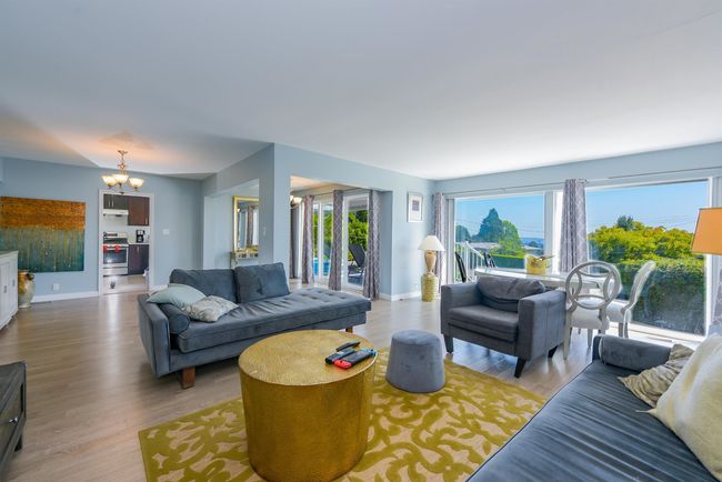 Living area with a chandelier, wood finished floors, and baseboards | Image 7