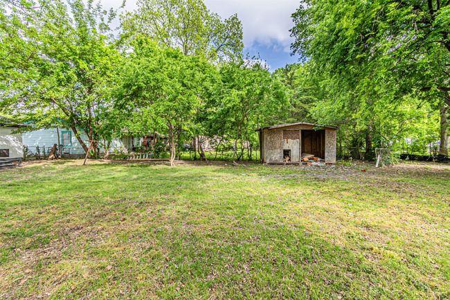 View of yard featuring fence, an outbuilding, and a storage shed | Image 27