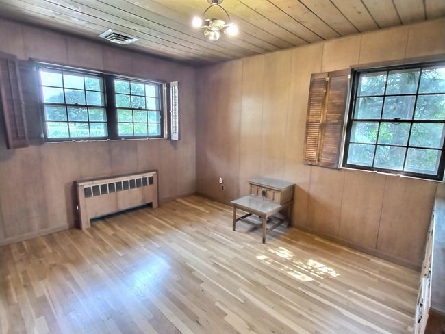 Spare room featuring radiator, wooden ceiling, and wood finished floors | Image 18